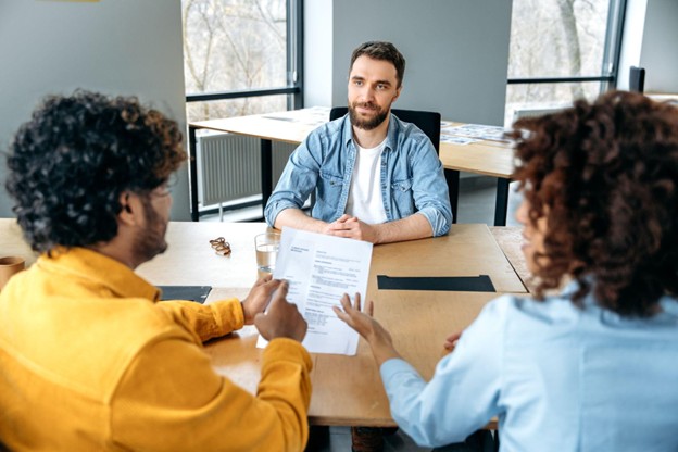 Recruiters review a candidate's resume during a structured interview to support data-driven hiring decisions.